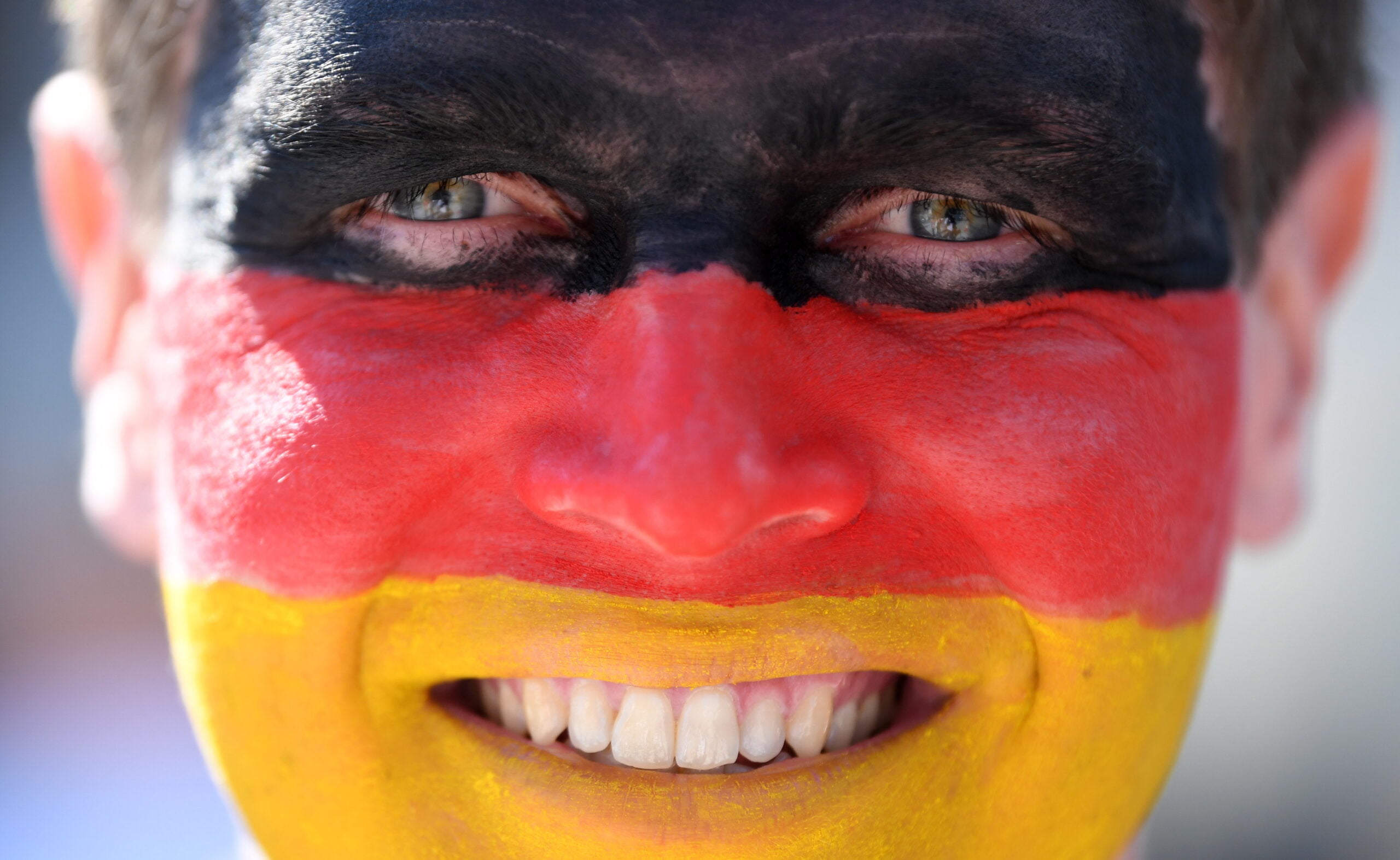 مشجع ألمانيا يطلو وجهه بعلم بلاده خلال مباراة ألمانيا واليابان